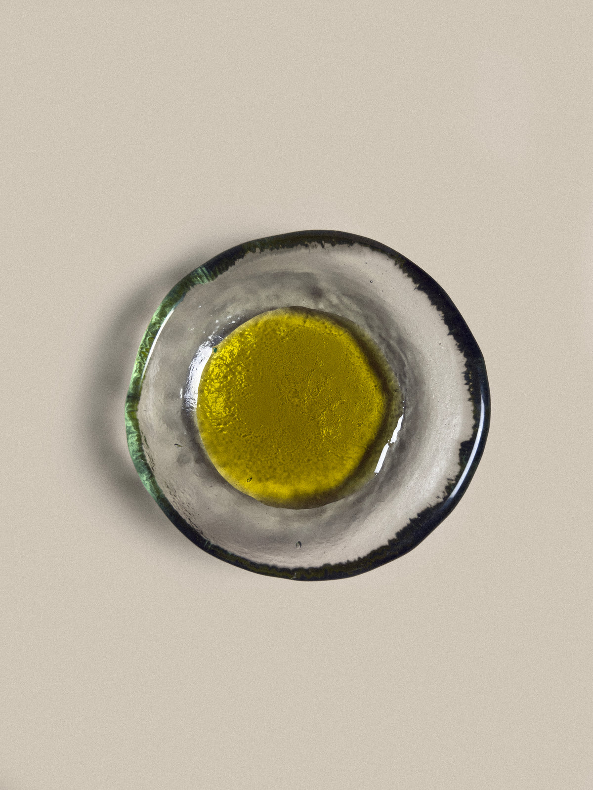 Round ceramic dish with a yellow center on a beige background